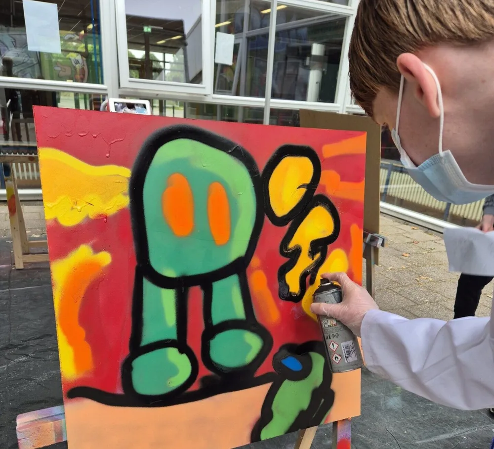 Kinderen werken aan een graffitiwerk tijdens het graffitiproject